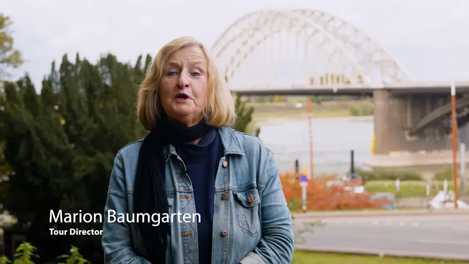 Marion Baumgarten on the Waalkade in Nijmegen, with the Waal bridge behind her